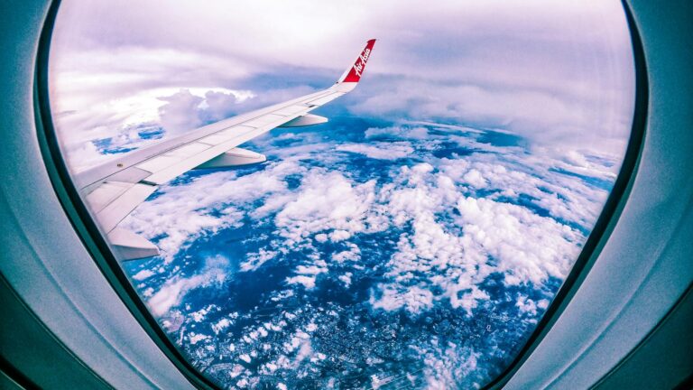 clouds and airplane wing from plane window