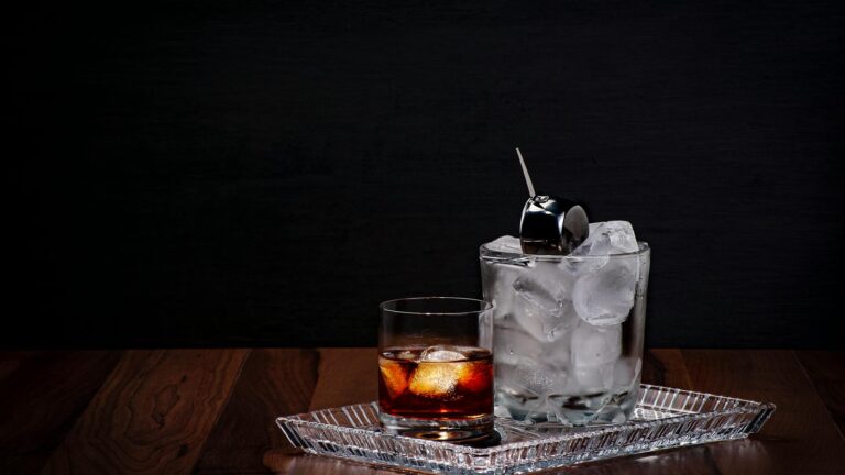 clear drinking glass with ice and black liquid
