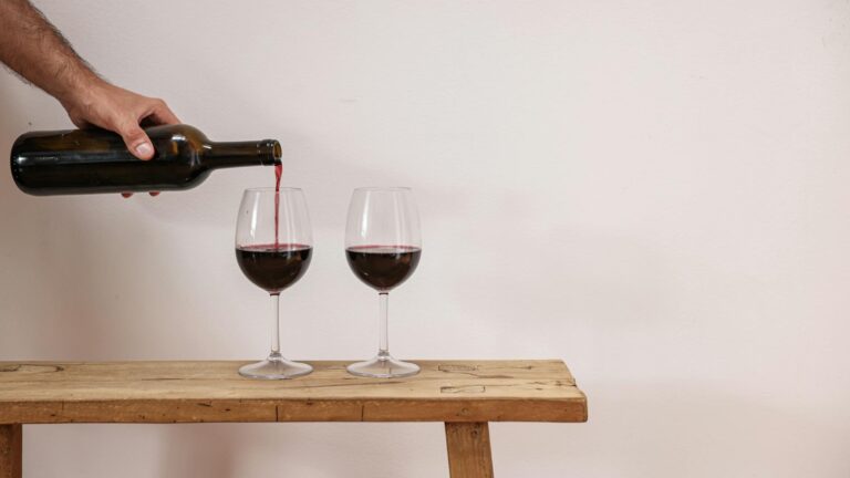 a person pouring red wine