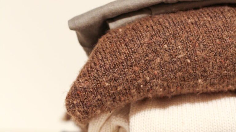 stack of folded sweaters on white background